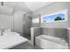 Bright bathroom featuring a glass shower, soaking tub, and a large window with scenic views at 3386 Governors Island Dr, Denver, NC 28037
