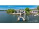 Lakefront home featuring a private dock with boat lifts and lakeside patio with seating areas at 3386 Governors Island Dr, Denver, NC 28037