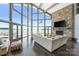 Spacious living room with expansive windows offering lake views, a stone fireplace and stylish furnishings at 3386 Governors Island Dr, Denver, NC 28037