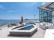 Modern outdoor pool and jacuzzi, alongside the lake and a large glass windowed home at 3386 Governors Island Dr, Denver, NC 28037