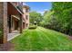 Lush, landscaped backyard with a covered patio area, and attractive brick exterior at 3815 Stoney Ridge Trl, Charlotte, NC 28210