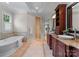 Luxurious bathroom showcasing dual vanities, a soaking tub, and a walk-in shower with decorative tiling at 3815 Stoney Ridge Trl, Charlotte, NC 28210