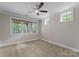 Bright bedroom features neutral walls, a ceiling fan, and large windows with backyard views at 3815 Stoney Ridge Trl, Charlotte, NC 28210