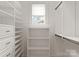 Bright walk-in closet with custom built-in shelving and ample storage space and a window for natural light at 3815 Stoney Ridge Trl, Charlotte, NC 28210