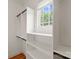 Bright walk-in closet with custom built-in shelving and ample storage space and a window for natural light at 3815 Stoney Ridge Trl, Charlotte, NC 28210
