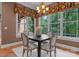 Dining area featuring a square table, seating for four, and large windows with decorative valances at 3815 Stoney Ridge Trl, Charlotte, NC 28210