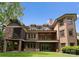 Rear exterior view of a brick house featuring a large balcony and screened porch at 3815 Stoney Ridge Trl, Charlotte, NC 28210