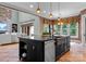 Kitchen island with granite countertops and a sink, adjacent to an open living area with stone fireplace at 3815 Stoney Ridge Trl, Charlotte, NC 28210