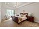 Elegant bedroom with a decorative chandelier, a cozy chair and a large window at 405 Gladelynn Way, Waxhaw, NC 28173