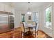 Bright breakfast nook with a round table, hardwood floors, and a built-in wine fridge at 405 Gladelynn Way, Waxhaw, NC 28173