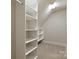 Walk-in closet with carpet flooring and built-in shelving units, providing ample storage at 405 Gladelynn Way, Waxhaw, NC 28173