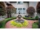 Decorative fountain surrounded by manicured landscaping offers a tranquil focal point in the yard at 405 Gladelynn Way, Waxhaw, NC 28173