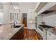 The gourmet kitchen features a central island, granite countertops, wooden flooring, and premium stainless steel appliances at 405 Gladelynn Way, Waxhaw, NC 28173