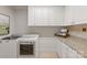 Bright laundry room with white cabinets, granite countertops, and modern appliances offers a functional and stylish space at 405 Gladelynn Way, Waxhaw, NC 28173