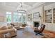 Cozy living room with a fireplace, built-in bookshelves, and large windows at 405 Gladelynn Way, Waxhaw, NC 28173