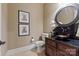 Chic powder room with a vessel sink, dark wood vanity, and decorative artwork presents a stylish and sophisticated space at 405 Gladelynn Way, Waxhaw, NC 28173