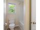 Bathroom with a toilet and bathtub, featuring neutral walls and flooring, and a window to the outside at 4100 B Christine Ln, Waxhaw, NC 28173