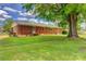 A beautiful brick house with a well-maintained lawn and an impressive, mature tree in the backyard at 413 N Mulberry St, Cherryville, NC 28021