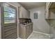 Functional laundry room with cabinets, sink, and a door leading outside at 413 N Mulberry St, Cherryville, NC 28021