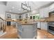 Spacious kitchen with white cabinets, granite countertops, large island, stainless steel appliances, and modern lighting at 4429 Cameron Oaks Dr, Charlotte, NC 28211