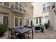 A lovely patio features an outdoor dining set and cozy seating area with a view of the building's architecture at 4429 Cameron Oaks Dr, Charlotte, NC 28211