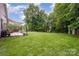 Large backyard with a green lawn, patio, and storage building at 5252 Ramblewoods Ave, Claremont, NC 28610