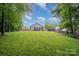 Large, green backyard featuring a spacious lawn, patio, and a wooded perimeter for privacy at 5252 Ramblewoods Ave, Claremont, NC 28610