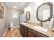 Bathroom featuring a double vanity, granite countertops, decorative mirrors, and tile flooring at 5252 Ramblewoods Ave, Claremont, NC 28610