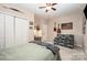 Cozy bedroom featuring a ceiling fan, comfortable chair, and neutral décor at 5252 Ramblewoods Ave, Claremont, NC 28610