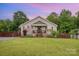 Charming single-Gathering home boasts a well-manicured lawn and cozy, covered front porch with brick steps at 5252 Ramblewoods Ave, Claremont, NC 28610