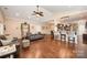 Spacious living room featuring hardwood floors, a ceiling fan, and seamless access to the kitchen area at 5252 Ramblewoods Ave, Claremont, NC 28610