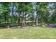 Tranquil backyard with mature trees, landscaping, and a bird feeder for wildlife enjoyment at 5718 Bardsey Ct, Matthews, NC 28104