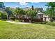 Lush backyard with a well-manicured lawn, brick patio, and mature trees creating a private setting at 5718 Bardsey Ct, Matthews, NC 28104