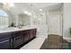 Elegant bathroom with a double vanity, large mirrors, and a glass-enclosed shower, offering a luxurious and modern feel at 5718 Bardsey Ct, Matthews, NC 28104