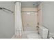 Standard bathroom with a shower and bathtub combination, tiled walls, and a white toilet at 5718 Bardsey Ct, Matthews, NC 28104