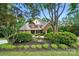 Two-story brick home with lush landscaping including a fountain, enhancing its curb appeal at 5718 Bardsey Ct, Matthews, NC 28104
