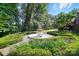 Serene backyard featuring a decorative fountain, manicured hedges, and natural landscaping at 5718 Bardsey Ct, Matthews, NC 28104
