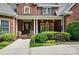 Inviting front porch with decorative columns, seasonal wreath and lush landscaping at 5718 Bardsey Ct, Matthews, NC 28104