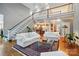 Open-concept living space with staircase, hardwood floors, and comfortable seating arrangement at 5718 Bardsey Ct, Matthews, NC 28104