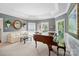 Cozy living room features a piano, and large windows providing natural light at 5718 Bardsey Ct, Matthews, NC 28104