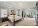 Luxurious main bedroom with tray ceiling, chandelier, sitting area, and natural light at 5718 Bardsey Ct, Matthews, NC 28104