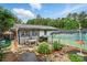 Spacious backyard featuring a greenhouse, patio with table, and lush landscaping at 6221 Thermal Rd, Charlotte, NC 28211