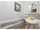 Small, well-lit half bathroom features a pedestal sink, decorative accessories, and a wall mirror at 6221 Thermal Rd, Charlotte, NC 28211