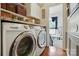 Modern laundry room featuring stainless steel washer and dryer, granite countertops, and wood floors at 6221 Thermal Rd, Charlotte, NC 28211