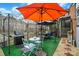 Charming patio with an orange umbrella, outdoor kitchen, table and chairs for outdoor dining at 6221 Thermal Rd, Charlotte, NC 28211