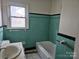 Bathroom featuring an original bathtub, sink, and large window at 6407 Market St, Charlotte, NC 28215
