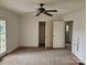 This bedroom features an open closet, ceiling fan, and light-filled windows at 6407 Market St, Charlotte, NC 28215