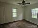 This bedroom offers natural light from the dual windows and a ceiling fan at 6407 Market St, Charlotte, NC 28215