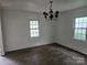 Dining room with hardwood floors, classic chandelier, and natural light from two windows at 6407 Market St, Charlotte, NC 28215