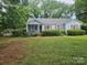Charming single-story home with light blue siding, red shutters, and a cozy screened front porch at 6407 Market St, Charlotte, NC 28215
